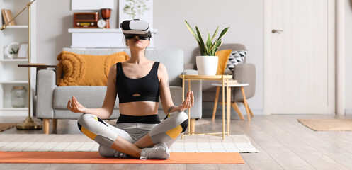 Sporty young woman with VR glasses meditating at home