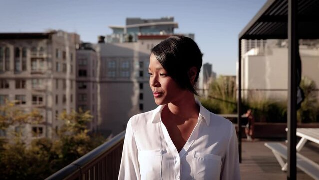 Portrait of a mixed ethnicity (Asian-African) business woman. Downtown buildings can be seen in the background.