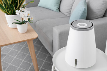 Modern humidifier on table in interior of living room