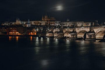Fototapeta na wymiar Moonlit Magic: Charles Bridge, Prague Castle, and Vltava River Reflections in Prague's Enchanting Night