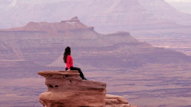 Asian woman hiking through the amazing landscape near Moab Utah, USA.