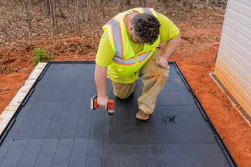 One of tasks involved in building plastic vinyl storage shed is screwing plastic base platform