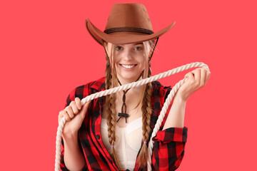 Young cowgirl with lasso on red background, closeup