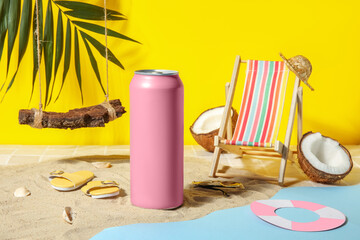 Can of soda with beach decor on sand near yellow wall