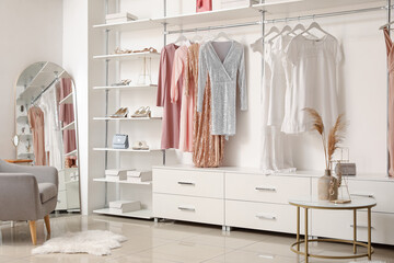 Stylish female clothes and shoes in boutique