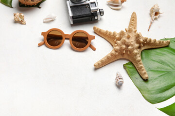 Composition with stylish sunglasses, palm leaf, starfish and seashells on light background