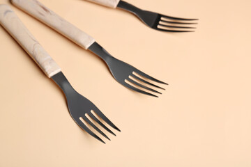 Stylish forks on beige background
