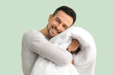Handsome man with soft blanket on green background