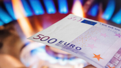Symbolic Representation of Commodity Payment: 500 Euro Banknote on Gas Flame Background
