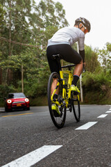 Fototapeta premium Cyclist Conquering the Mountain: Racing Uphill in a Road Competition