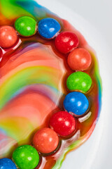 Fototapeta na wymiar Skittles Candy Ring Bleeding Colors White Background