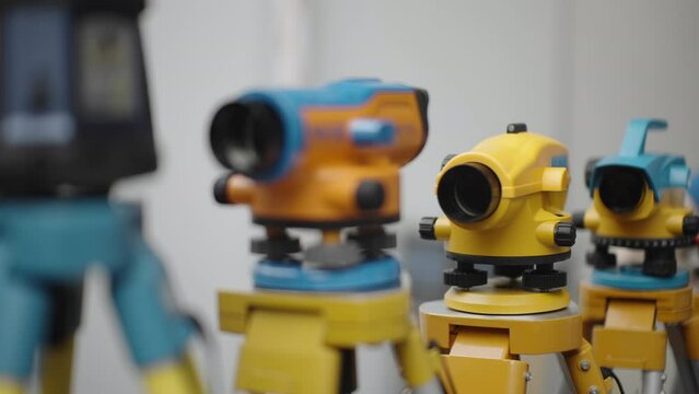 Surveying tools stand on tripods indoors