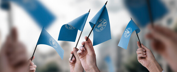 A group of people holding small flags of the Food and agriculture organization in their hands
