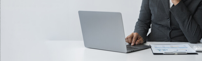 copy space, banner, panorama business woman working on the table sits analyzing graph data Document charts use a calculator to analyze business growth plans. Finance, Marketing and Accounting Concept