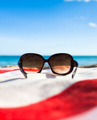 sunglasses on a beach towel against the beach