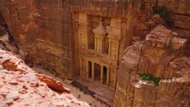 From Above View Of The Beautiful Al Khazneh (The Treasury) With Tourists Below In Petra, Jordan - drone shot