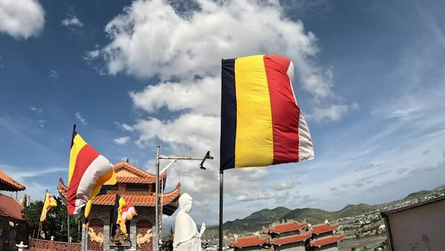 Slow motion Buddhist flag in a temple is waving on a strong wind