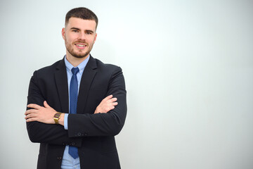 A happy young businessman Business man standing with crossed arms confident and smiling in the office white wall background