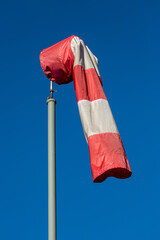 Red and white wind sock on a pole