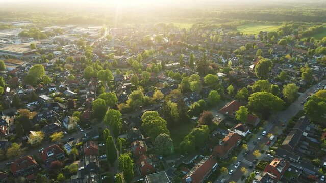 Jib down of a beautiful residential area at golden hour. The sun flares into the cameralens