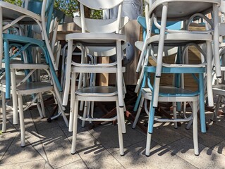 Des chaises bleues et blanches empilées. Des chaises de bar empilées. Piles chaises. Fin de la fête. Fermeture de bar. Des chaises de couleur pastel.