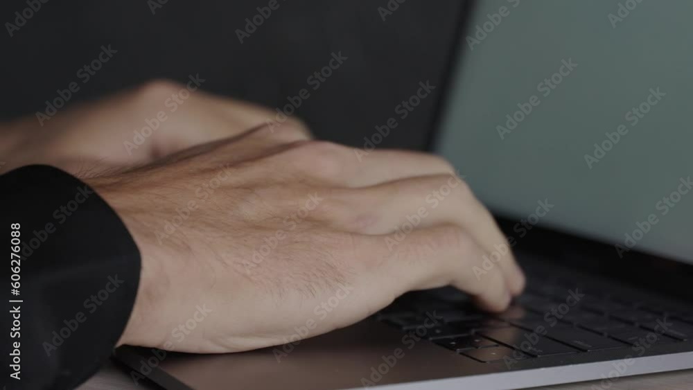 Poster focused man concentrates as he writes on a keyboard, his fingers dancing across the keys with precis