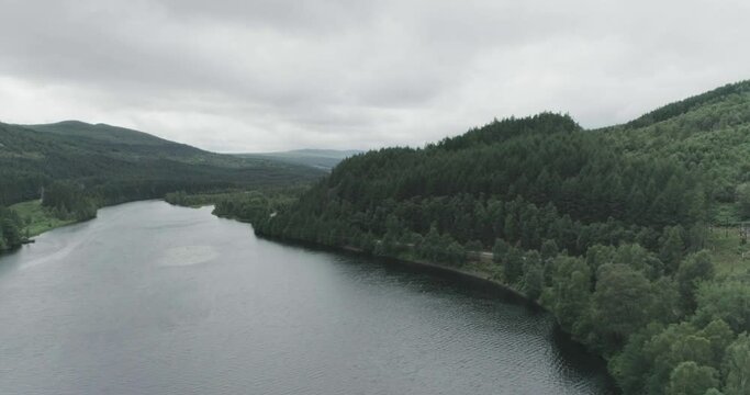 Wide drone shot of Dundreggan Reservoir and the surrounding forests, dense trees in the Scottish Highlands near Fort Augustus