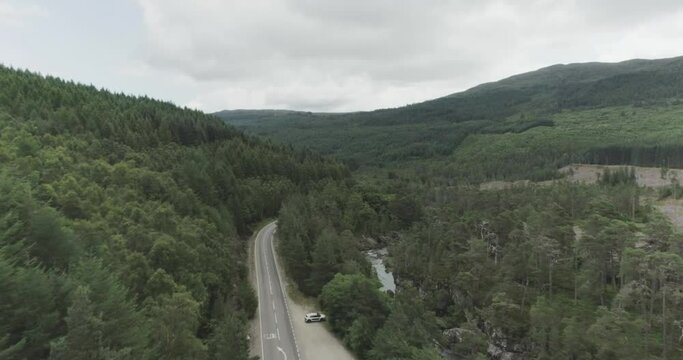 Mid drone shot of waterfalls, reservoir dam wall and the surrounding forests along the North Coast 500 route to Fort Augustus and Loch Ness
