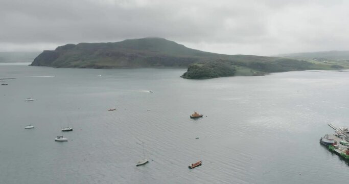Wide drone shot of moored and moving boats in Loch Portree on the Isle of Skye