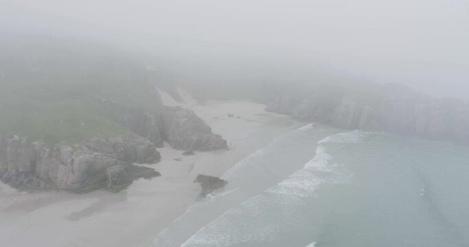 Drone shot in the mist of big waves on Ceannabeinne Beach on the Scotland North Coast 500 Route which is the North Sea