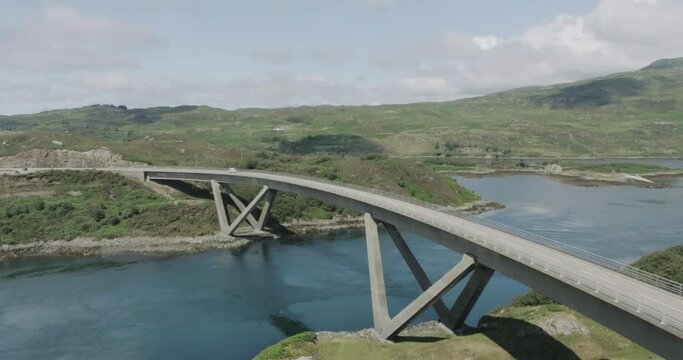 Push in and tilt drone shot of campervan driving over Kylesku Bridge along scotland northcoast 500 route