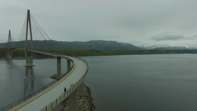 Cyclist and car approaching the Helgeland Bridge in Norway