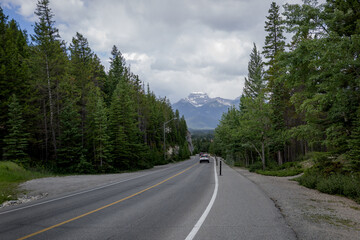 Windy road in Banff National Park, Banff, Alberta, Canada. cars parking. Mountain road with forest and cliffs. 