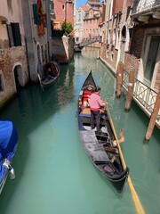 Venezianische Gondel mit Gondoliere auf grünem Lagunen Wasser in Italien und Venedig 