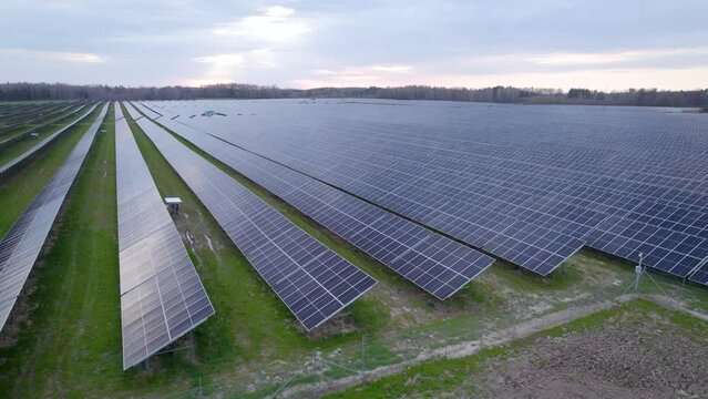 Vast solar farm covered under PV solar panels, daytime aerial view