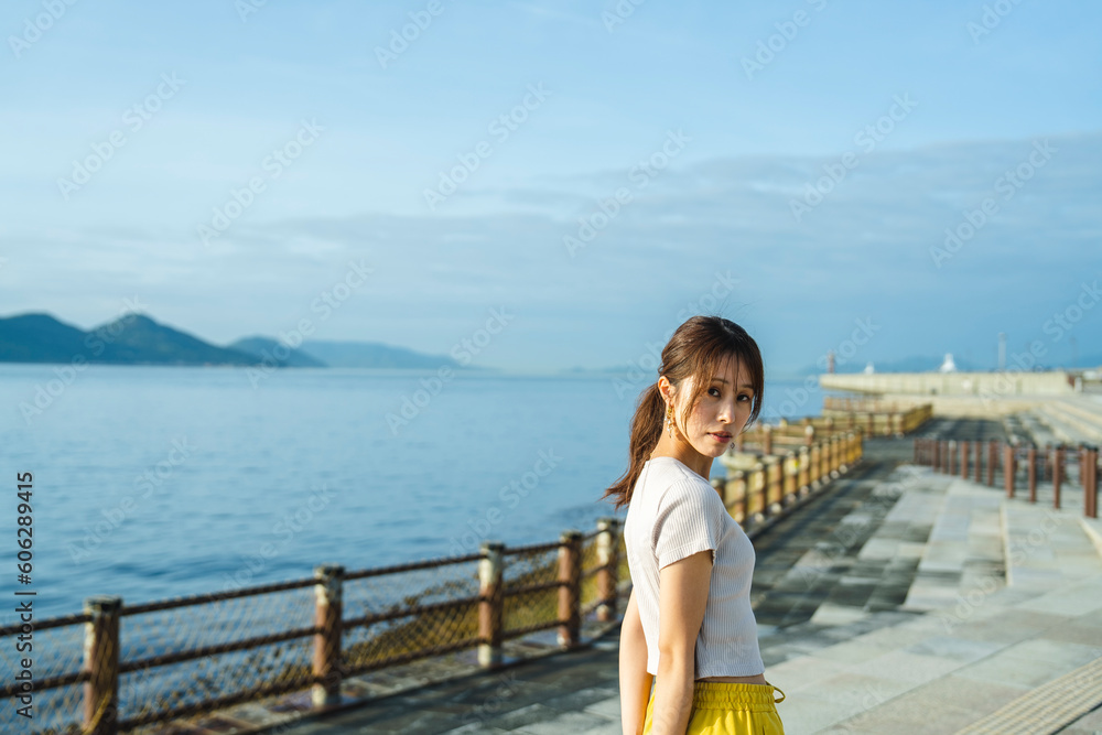 Wall mural 夕暮れの海にいる女性