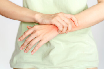 Fototapeta na wymiar A woman touches her wrist because of an injury or rheumatoid arthritis.