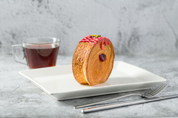 New York roll or round croissant with marmalade with tea on stone table