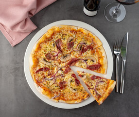 Bacon and mushroom pizza on porcelain plate on stone table