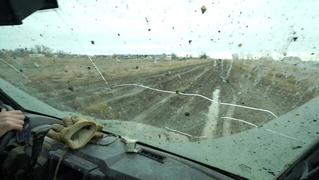 Gimbal - looking out muddy windshield of UTV as it slides in Montana gumbo
