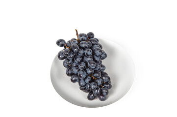 Branch of ripe blue grape on plate isolated white background. Juicy grapes with copy space