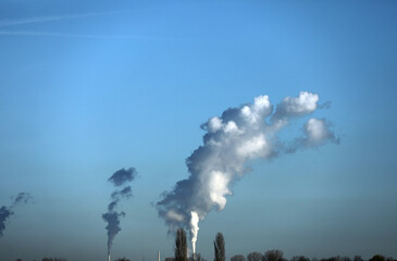 Industrial chimney with white smoke