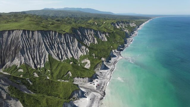 Aerial panoramic view of white rocks and coastline of Iturup Island washed by Sea of Okhotsk, Kuril islands