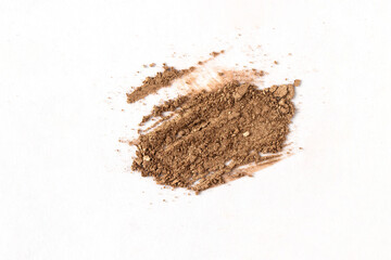 Top view of brown nude eyeshadow swatch on isolated background. Crashed smear with shimmer powder...