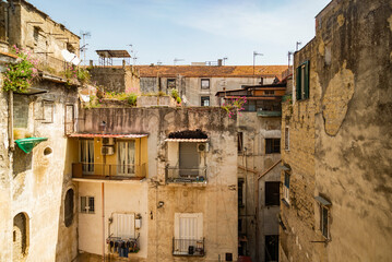 Facade in an inner courtyard in old town Centro storico of italian metropole Naples. Balconys and...