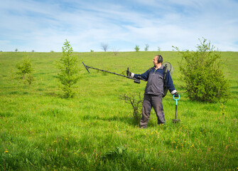 Metal search. A man holds a metal detector in his hand. Search for treasures. Search for antique coins.