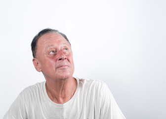 Serious middle-aged man thinking about things on isolated white background