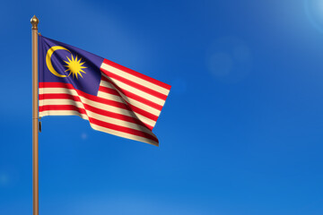 Malaysia. Flag blown by the wind with blue sky in the background.