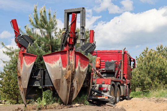 Tree transplanter heavy machine. machine for transplanting large trees. Planting large spruce trees in the park.  Landscaping, spring agricultural engineering, trees landing machines. Agrotechnology