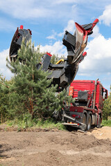 Tree transplanter heavy machine. machine for transplanting large trees. Planting large spruce trees...